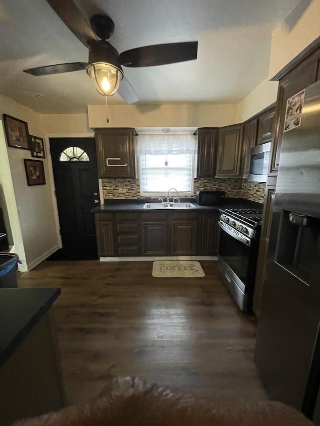 kitchen featuring stainless steel appliances, a sink, and dark brown cabinetry