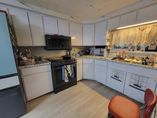 kitchen featuring backsplash, white cabinets, light hardwood / wood-style floors, and black range with electric cooktop