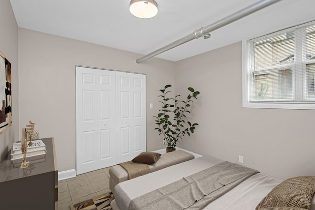 bedroom featuring light tile patterned floors and a closet