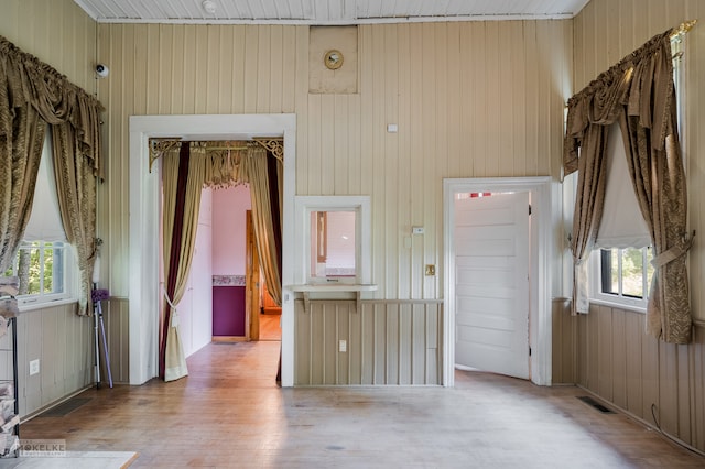 empty room with wood walls and hardwood / wood-style flooring