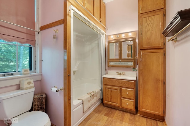 full bath with tub / shower combination, toilet, vanity, and wood finished floors