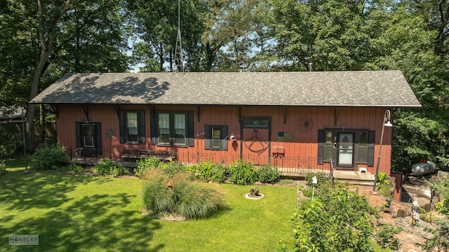 view of front of home featuring a front yard and a shingled roof