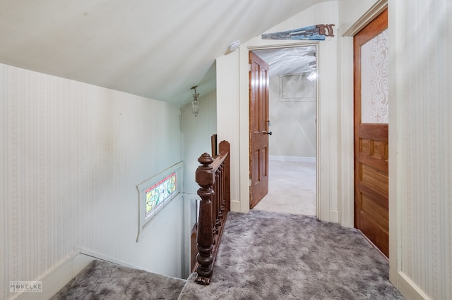 corridor featuring vaulted ceiling and carpet flooring