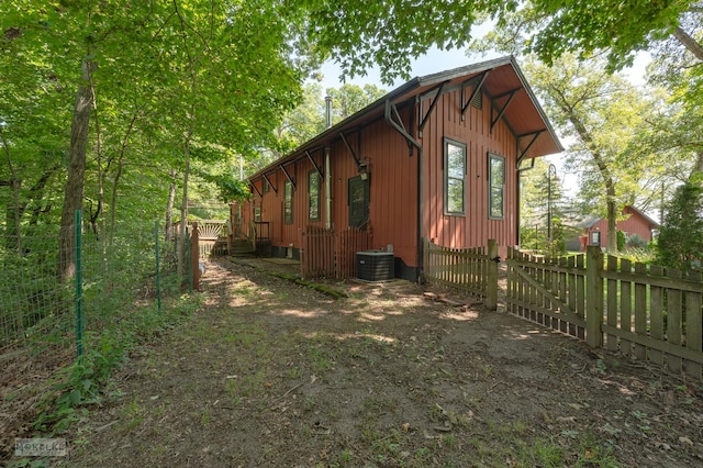 view of side of property featuring central AC unit, a deck, and fence