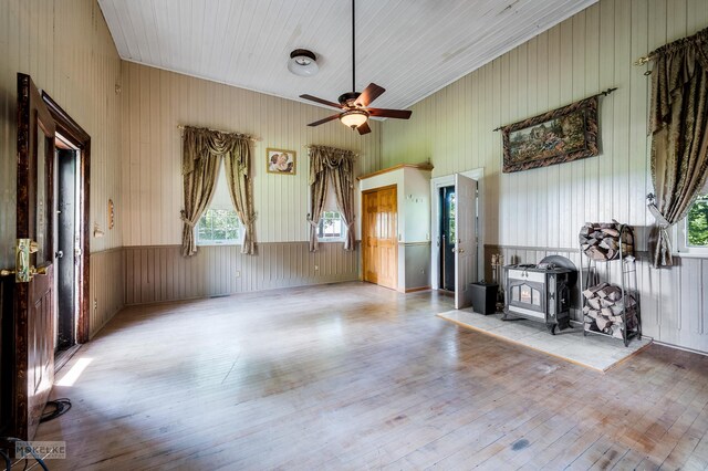 interior space featuring ceiling fan, light hardwood / wood-style flooring, and a wood stove