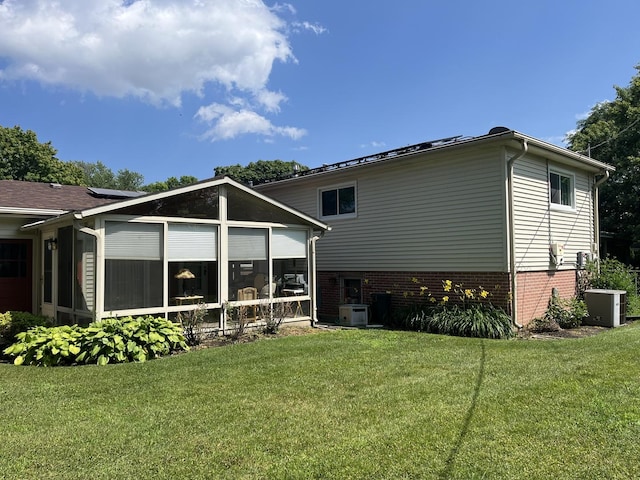 back of house featuring a yard, central AC, and a sunroom