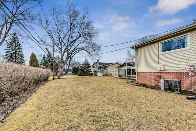 view of yard with central AC unit and a sunroom