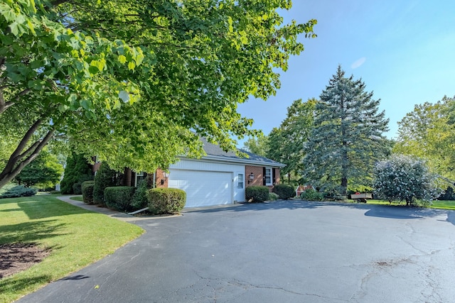 view of home's exterior with a garage and a lawn