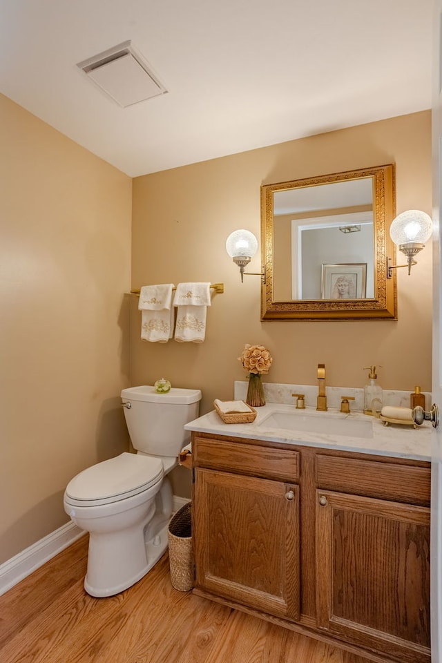 bathroom featuring wood-type flooring, vanity, and toilet