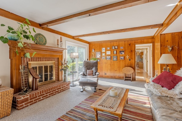 carpeted living room featuring beam ceiling, wooden walls, and a brick fireplace