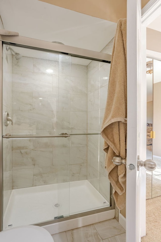 bathroom featuring tile patterned flooring, walk in shower, and toilet