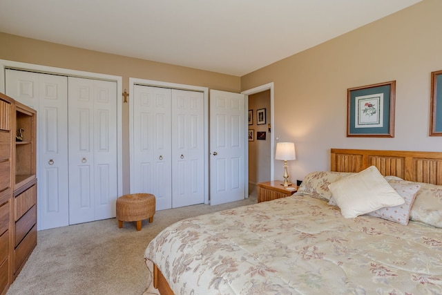 carpeted bedroom featuring two closets