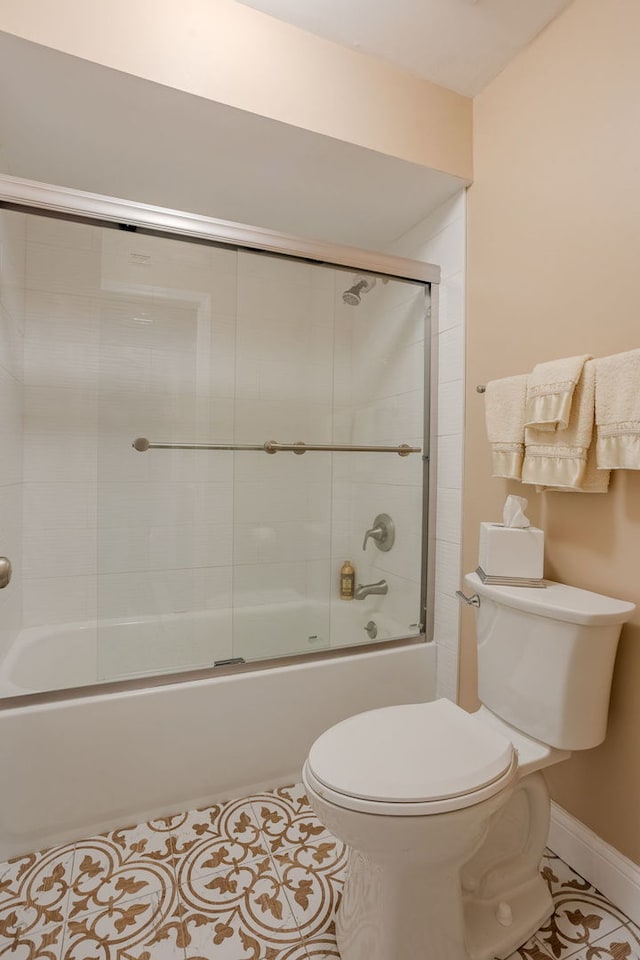 bathroom featuring tile patterned floors, shower / bath combination with glass door, and toilet