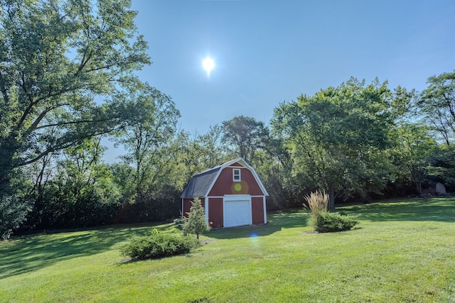 view of yard with a garage and an outbuilding