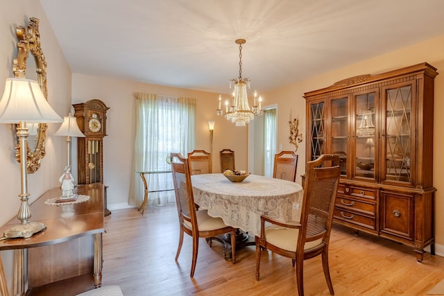 dining space featuring light hardwood / wood-style flooring and a notable chandelier