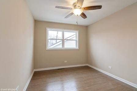 empty room featuring a ceiling fan, baseboards, and wood finished floors