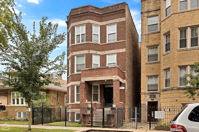 view of front of home with a fenced front yard and brick siding