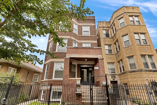 view of front of home featuring a fenced front yard and brick siding