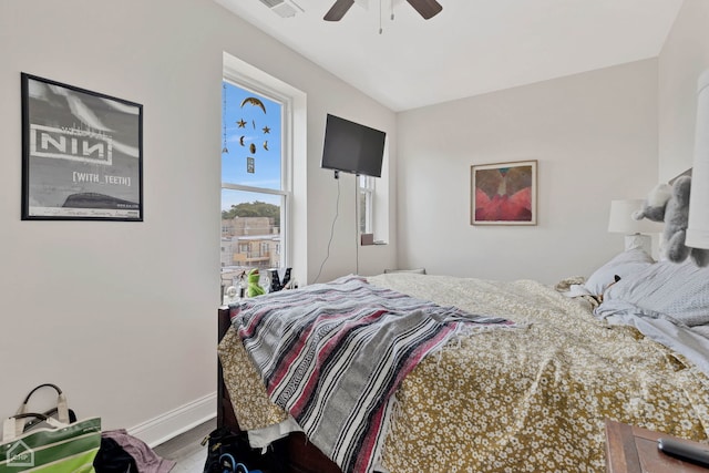 bedroom with ceiling fan, wood finished floors, visible vents, and baseboards