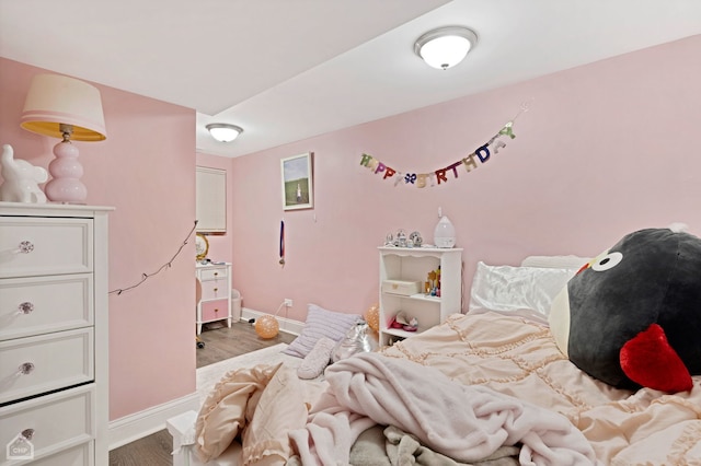 bedroom with baseboards and wood finished floors