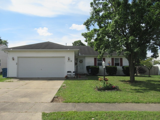 ranch-style house with a garage and a front lawn