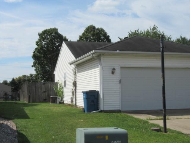 view of home's exterior with driveway, fence, and a yard