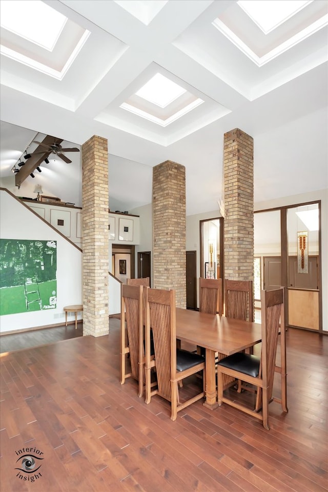 dining room featuring ceiling fan, dark hardwood / wood-style floors, beamed ceiling, and decorative columns