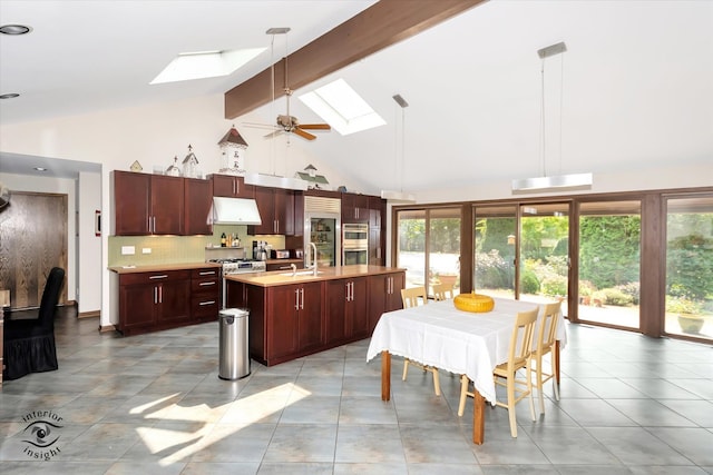 dining space featuring a skylight, sink, beamed ceiling, and a healthy amount of sunlight