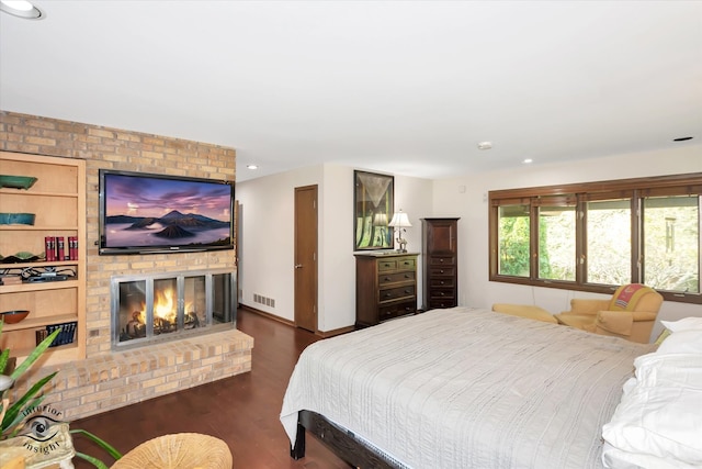 bedroom featuring a fireplace and dark hardwood / wood-style floors