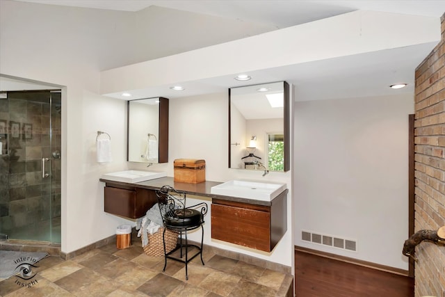 bathroom featuring lofted ceiling, a shower with shower door, hardwood / wood-style flooring, and vanity