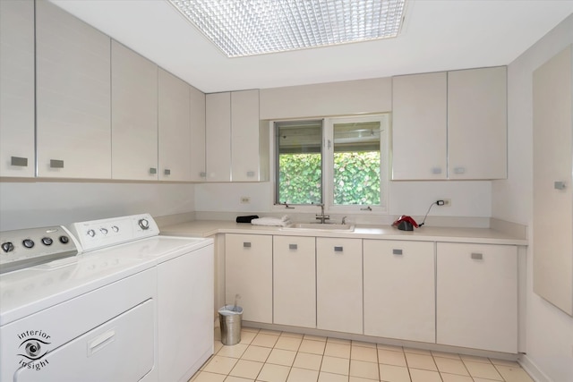 laundry room featuring cabinets, sink, light tile patterned flooring, and washing machine and dryer