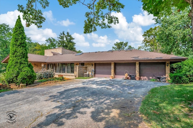 ranch-style house featuring a garage and a front lawn