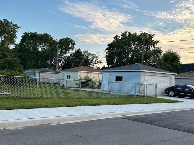 exterior space with a garage, an outbuilding, and a front yard