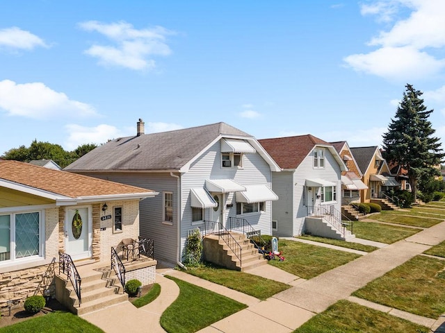 view of front of property with a residential view, roof with shingles, and a front lawn