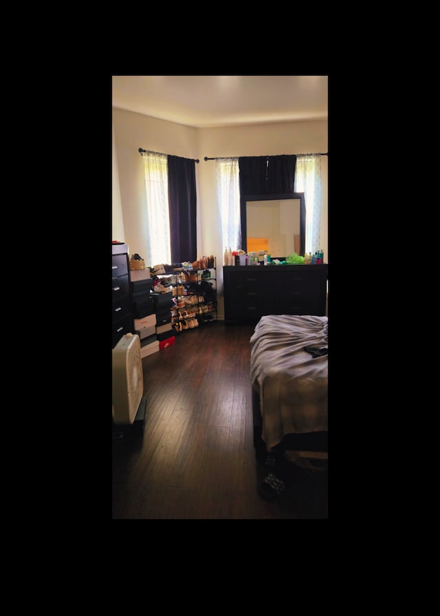 bedroom with dark wood-type flooring