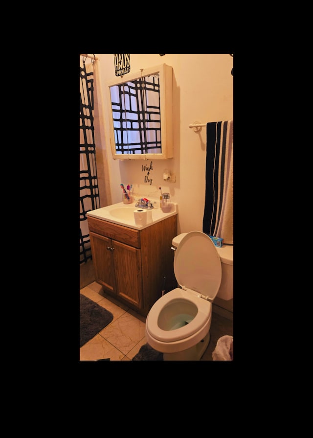 bathroom featuring toilet, vanity, and tile patterned floors