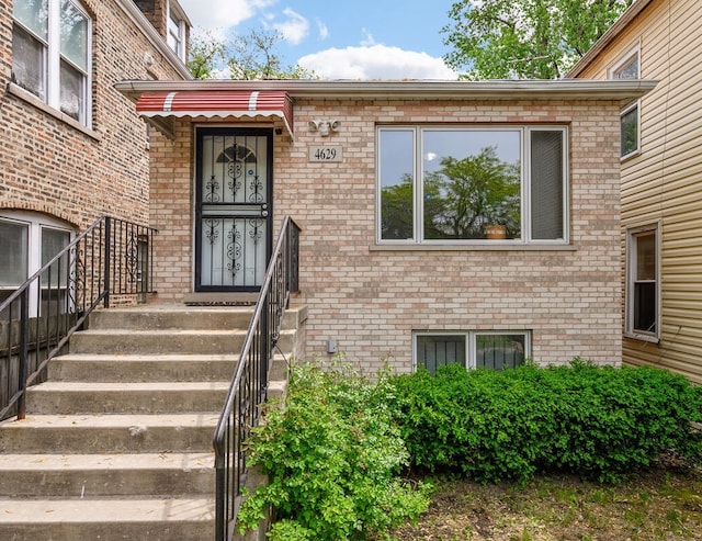 doorway to property featuring brick siding