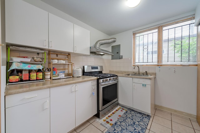 kitchen featuring stainless steel gas range oven, backsplash, white cabinets, sink, and light tile patterned flooring