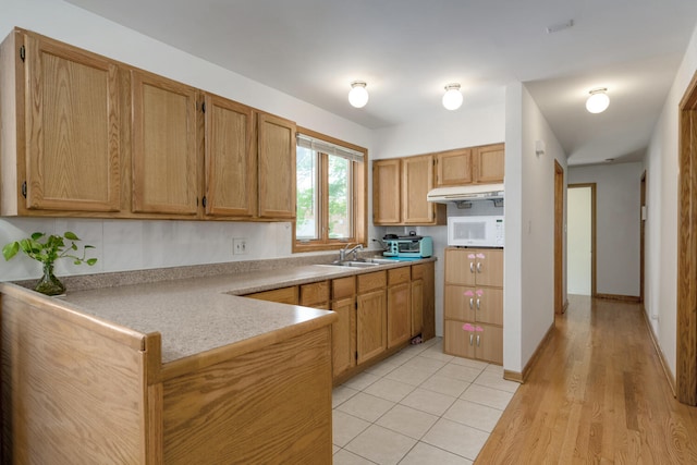 4629 S Laflin St, Chicago, IL 60609 - kitchen with white microwave, a peninsula, a sink, light countertops, and brown cabinetry
