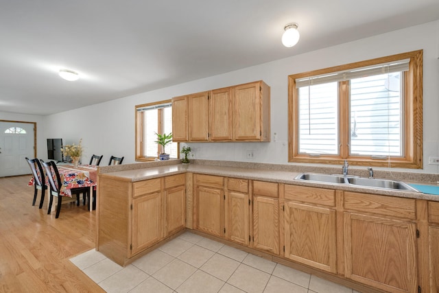 kitchen featuring sink, light wood-type flooring, kitchen peninsula, and light brown cabinets