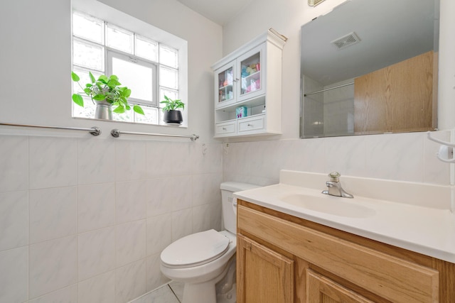 bathroom featuring toilet, tile walls, tile patterned flooring, and vanity