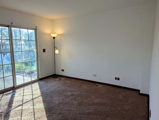 unfurnished room with dark colored carpet