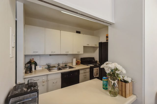 kitchen with sink, black appliances, and white cabinetry