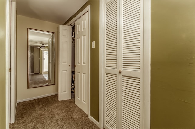 hallway featuring dark colored carpet