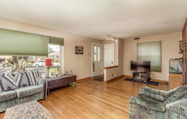 living area with visible vents, rail lighting, wood finished floors, and baseboards