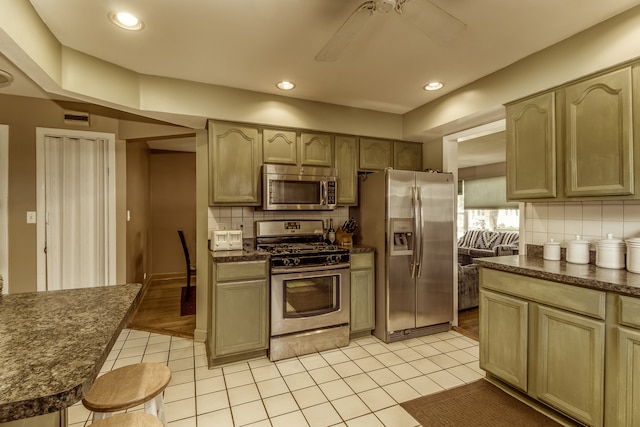 kitchen featuring ceiling fan, tasteful backsplash, appliances with stainless steel finishes, and light hardwood / wood-style flooring