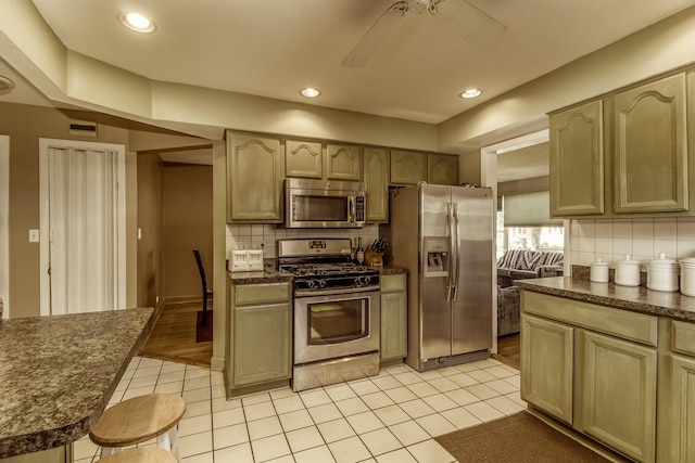 kitchen with stainless steel appliances, dark countertops, and backsplash