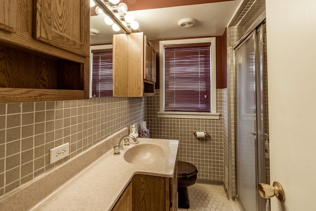 bathroom with vanity, toilet, tile patterned floors, and a shower with door