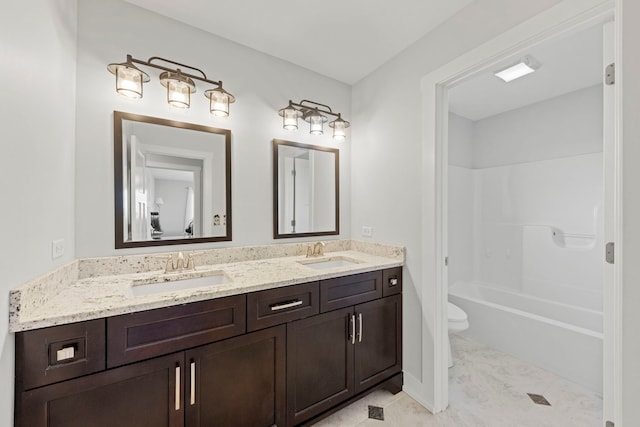 bathroom featuring a sink, bathing tub / shower combination, toilet, and double vanity