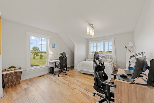 bedroom with track lighting, light hardwood / wood-style floors, and multiple windows